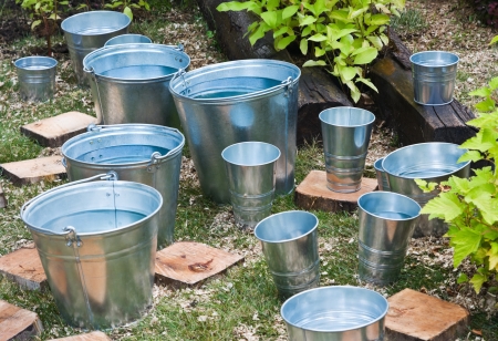 zinc bucket of water standing on the grassの写真素材