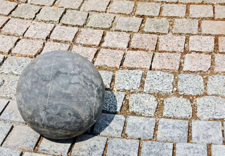 granite stone ball rests on the rocksの写真素材