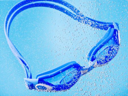 goggles for swimming fell into the water with bubblesの写真素材