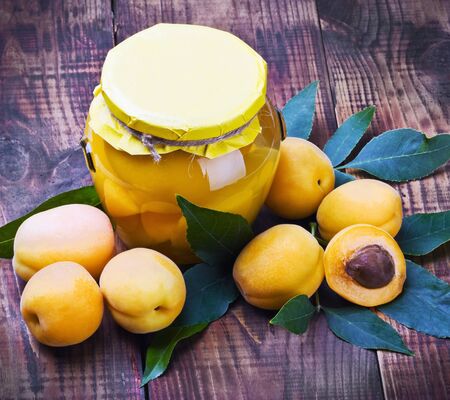 fresh and canned apricots on wooden floorの写真素材
