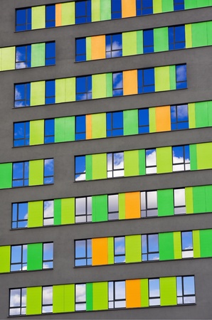 colorful wall of the building with reflective windows in the skyの写真素材
