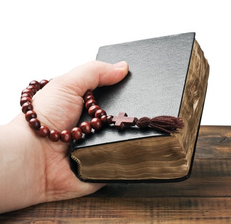 human hands holding the Bible and praying with a rosaryの写真素材