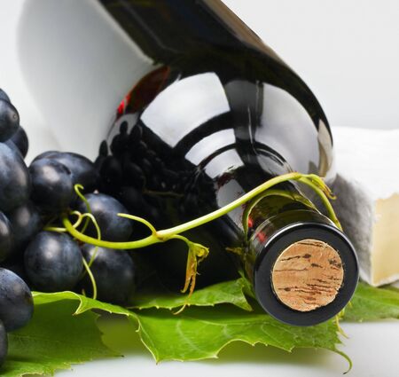 bottle of wine close-up on a background of grape and cheeseの写真素材