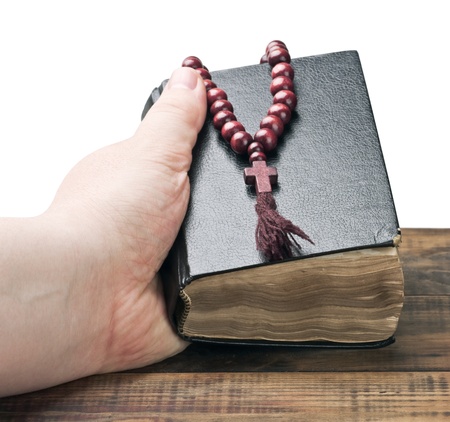 human hands holding the Bible and praying with a rosary の写真素材