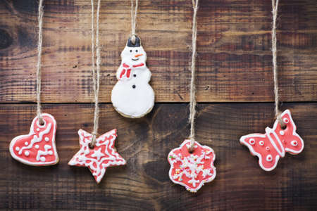 christmas gingerbread cookies hanging over wooden background の写真素材