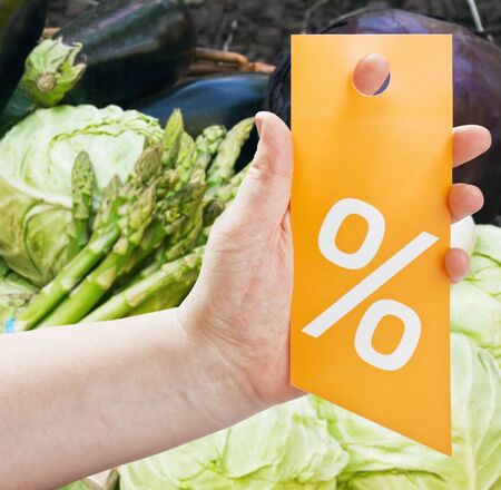 hand holding a card for discounts against products in the storeの写真素材