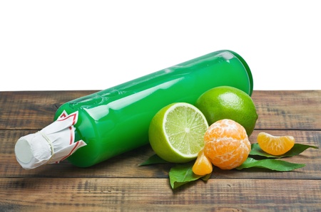 fresh citrus fruit and a bottle of juice on a wooden tableの写真素材