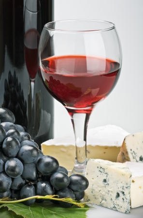 glass of red wine with bottle and grapeの写真素材