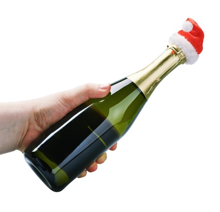 bottle of champagne in santa hat in hand isolated on white backgroundの写真素材