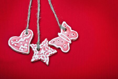 christmas gingerbread cookies hanging over red backgroundの写真素材