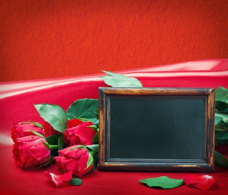 red roses and blackboard with space for text on a red background の写真素材