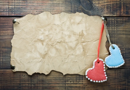 valentine cookies in the form of hearts hanging on a rope on the background of old paperの写真素材