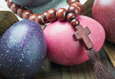 decorated with painted Easter eggs and an open bible wooden tableの写真素材