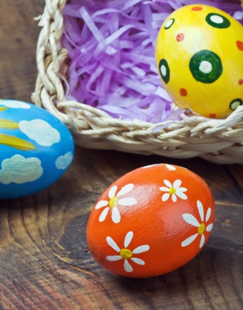 Painted Easter eggs in a basket on the tableの写真素材