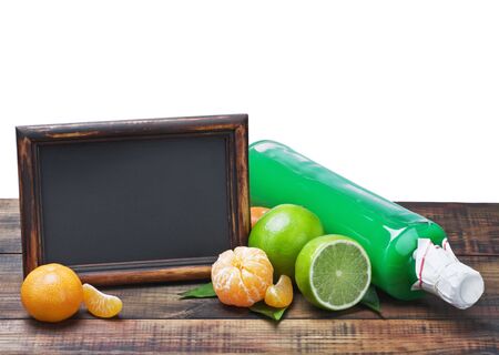 bottles of juice from citrus fruits and blackboard isolated on white backgroundの写真素材