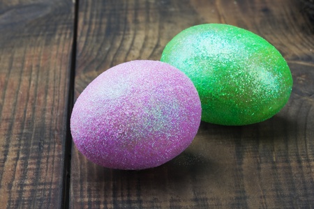 decorated with glitter easter egg on a wooden tableの写真素材
