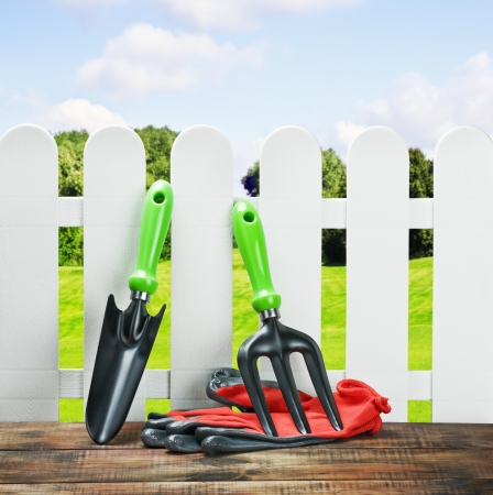 garden tools and a white fence on a landscapeの写真素材