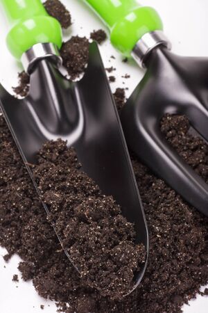 garden tools shovel and soil on white background の写真素材