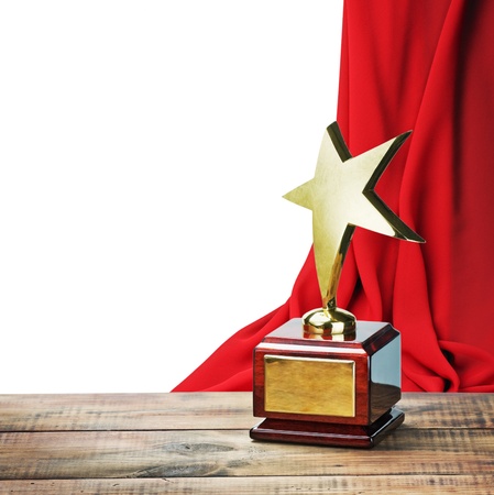 Star award wooden table and on the background of red curtain with space for textの写真素材