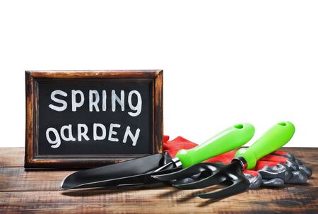 garden tools and a blackboard with the words in the spring gardenの写真素材