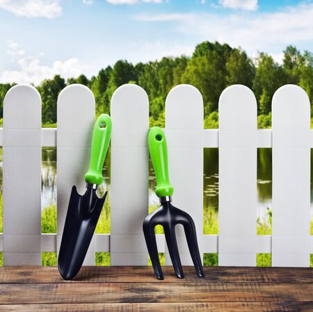garden tools and a white fence on a landscapeの写真素材