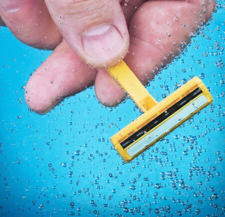 razor in his hand in pure waterの写真素材