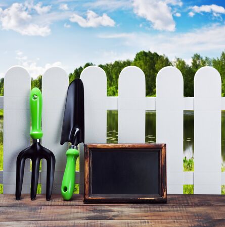 garden tools and equipment and a white fence on a landscapeの写真素材