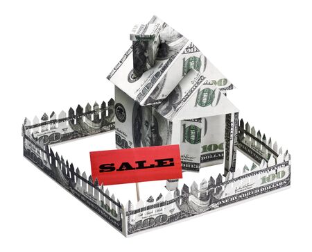 house made of money with a sign for sale isolated on white backgroundの写真素材