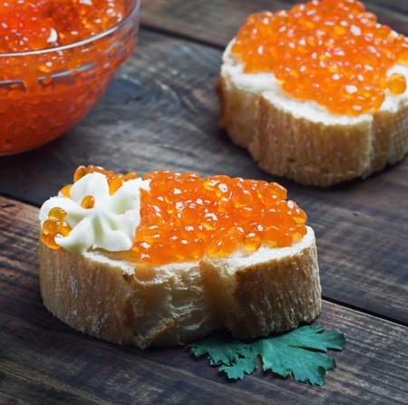 red caviar with butter on slices of baguette on the tableの写真素材