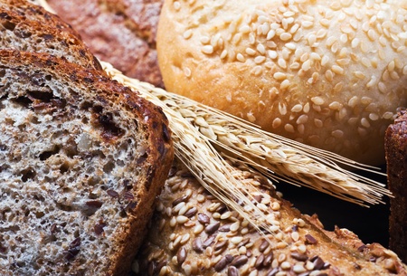 different assortment fresh bread and wheat ears close-up shotの写真素材