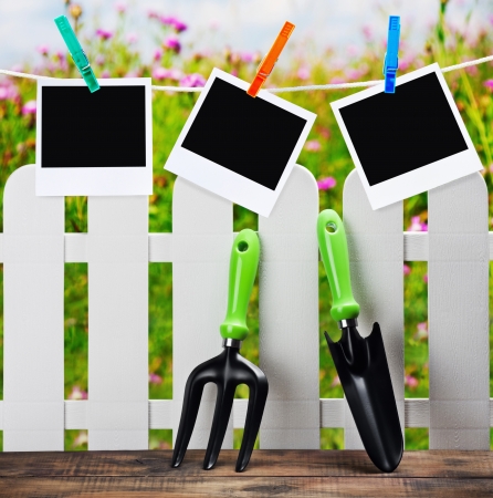 garden tools and photoframes on a clothespin on a background of flower fields の写真素材
