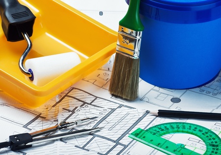 plastic can with paint, roller, brushes on a plan of repairの写真素材