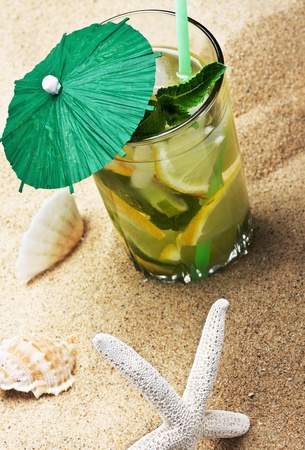 refreshing mojito cocktail on the sea sand with shellsの写真素材