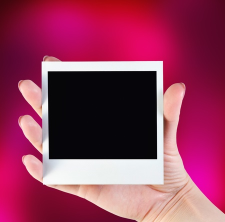 picture frame in her hand on a colorful red backgroundの写真素材