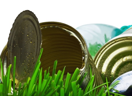 garbage from aluminum and tin cans on a green grass. Focus on the edges of the tin canの写真素材