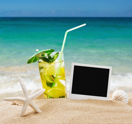 refreshing mojito cocktail on the sea sand with shellsの写真素材