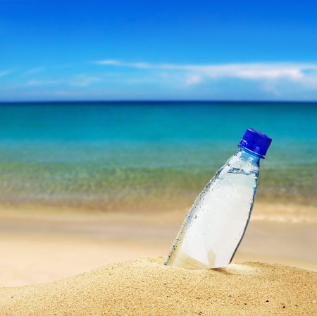 pet bottle with water on the sea sandの写真素材