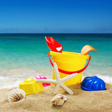 colorful toys for childrens sandboxes against the sea and the beachの写真素材