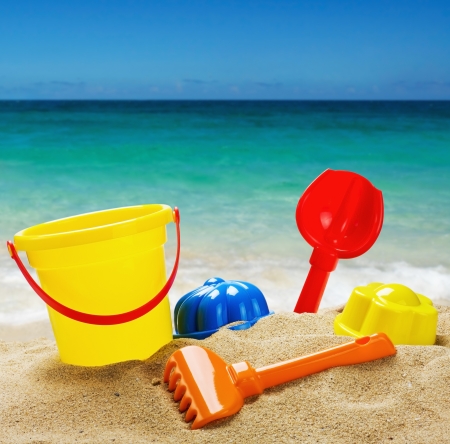 colorful toys for childrens sandboxes against the sea and the beachの写真素材