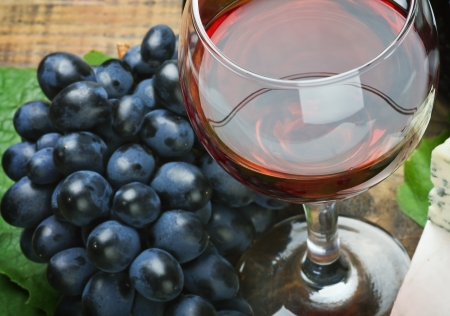 glass of red wine with bottle and grapeの写真素材
