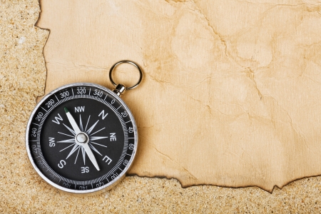Compass on old paper against the background of sandの写真素材