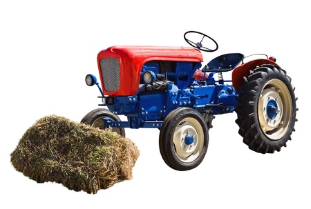 old tractor and a shock of hay isolated on a white backgroundの写真素材