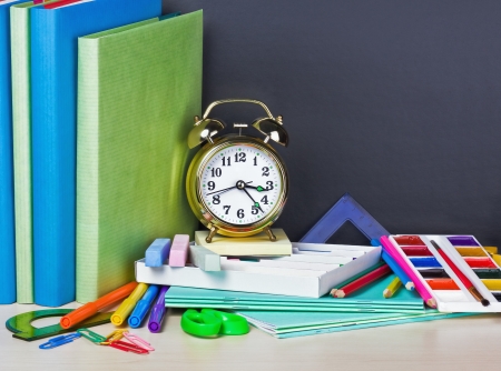 school supplies on the desk in the background of chalkboardの写真素材