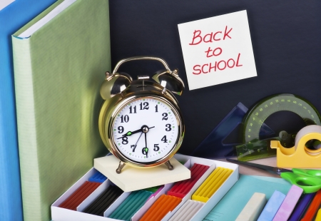 school supplies on the desk in the background of chalkboardの写真素材