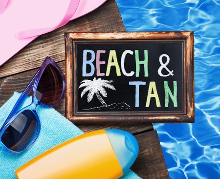 blackboard with the word beach and tan on the sea  の写真素材