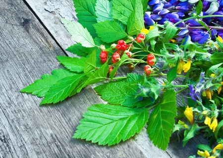 wild flowers and berries on a wooden tableの写真素材