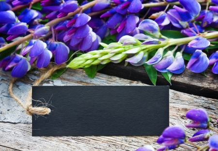wild flowers and label with space for text on a wooden tableの写真素材