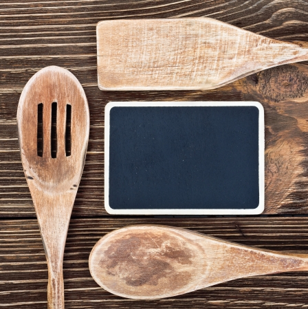 Wooden kitchen utensils and a blackboard to write a recipeの写真素材