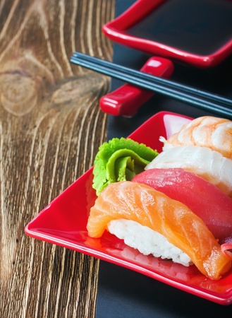 Japanese seafood sushi and chopstick on a red plateの写真素材