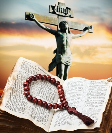 wooden rosary on the Bible against the crucifixion of Christの写真素材